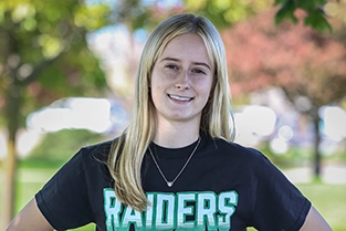 Female student wearing Central Community College Raiders t-shirt and smiling at the camera