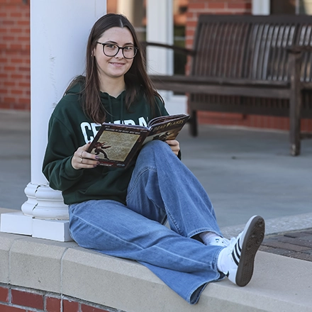 Student sitting outside on campus 