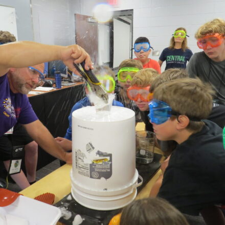 Professor demonstrating a science experiment with CHI campers.
