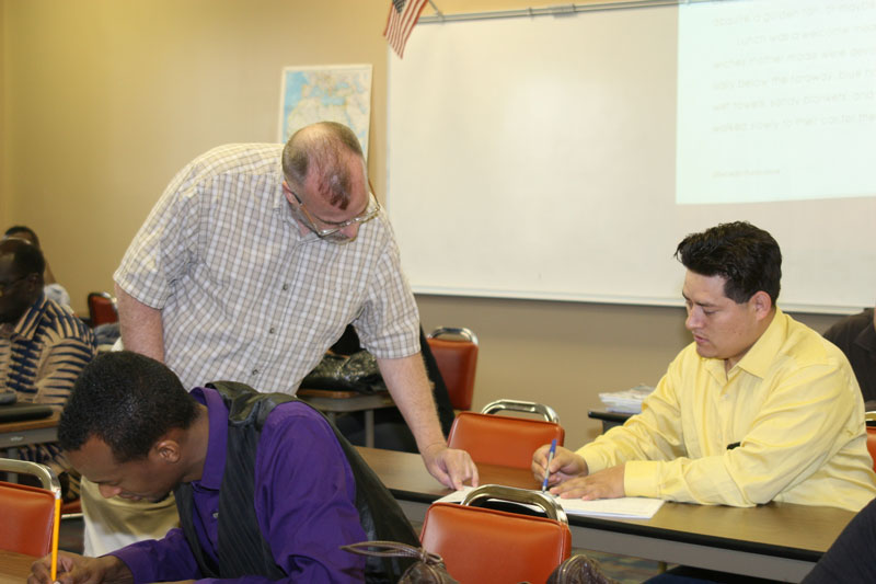 ESL teacher shows student how to fill out the worksheet.