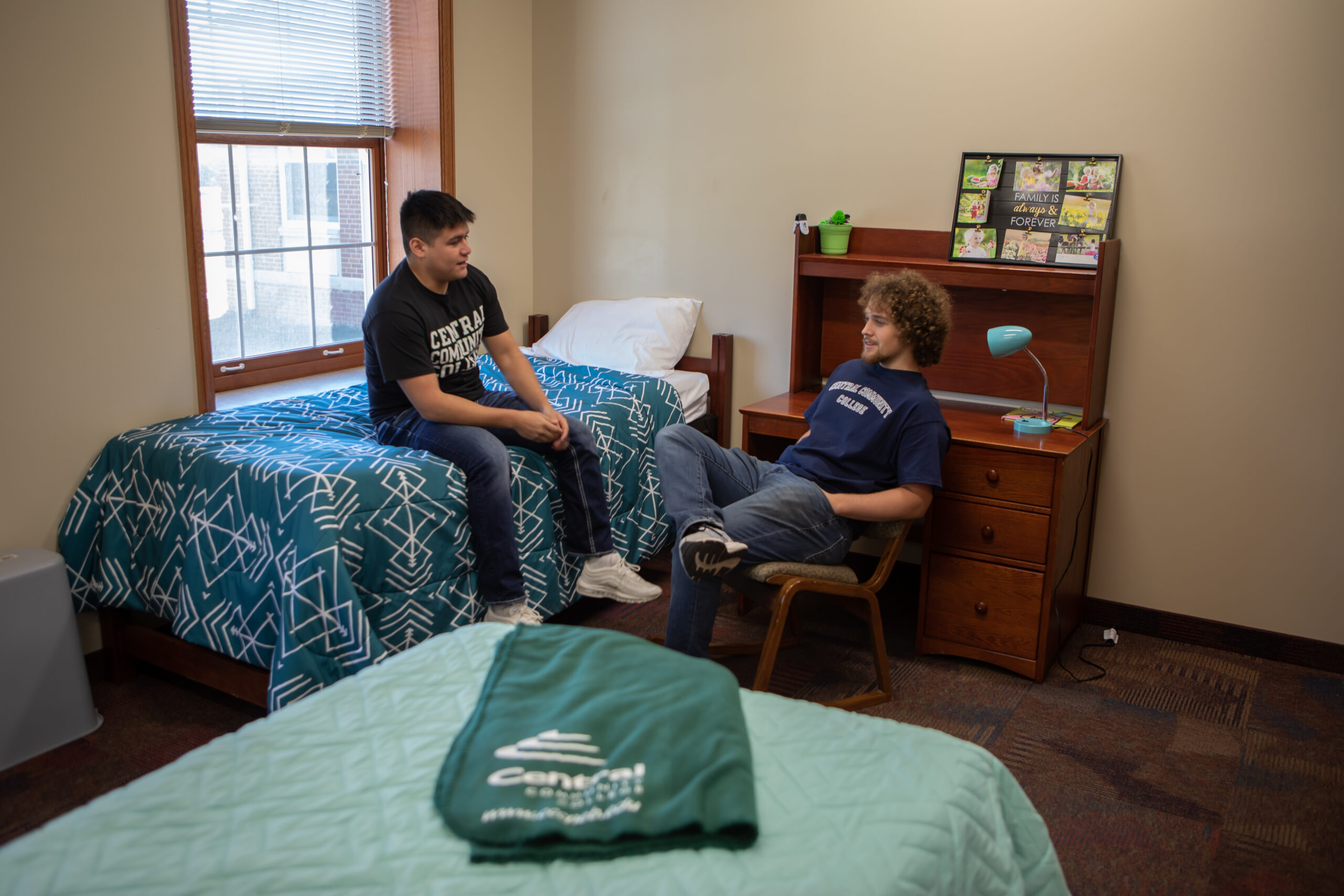 Two students sit in a residence hall room.