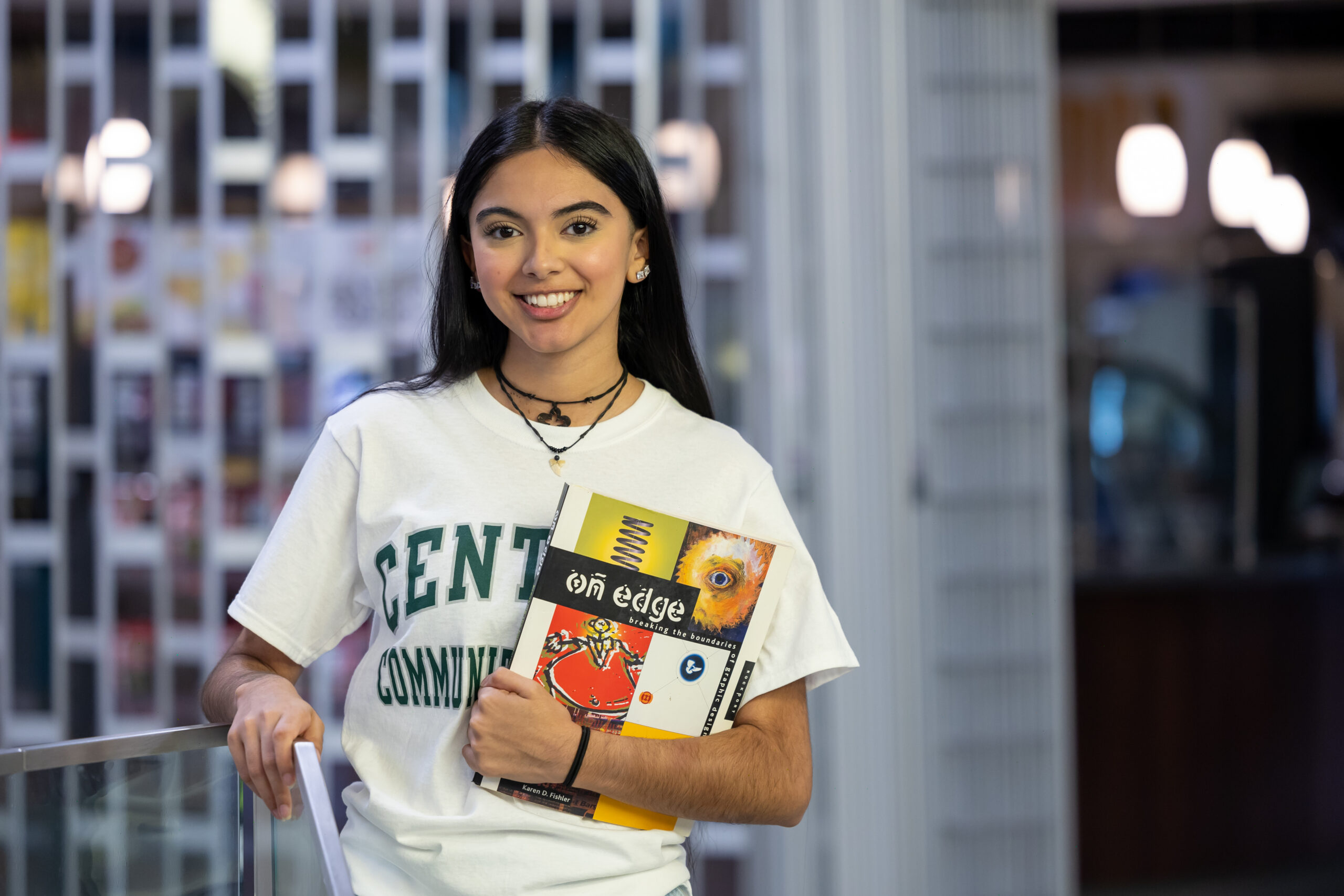 A student walking on campus with school books.