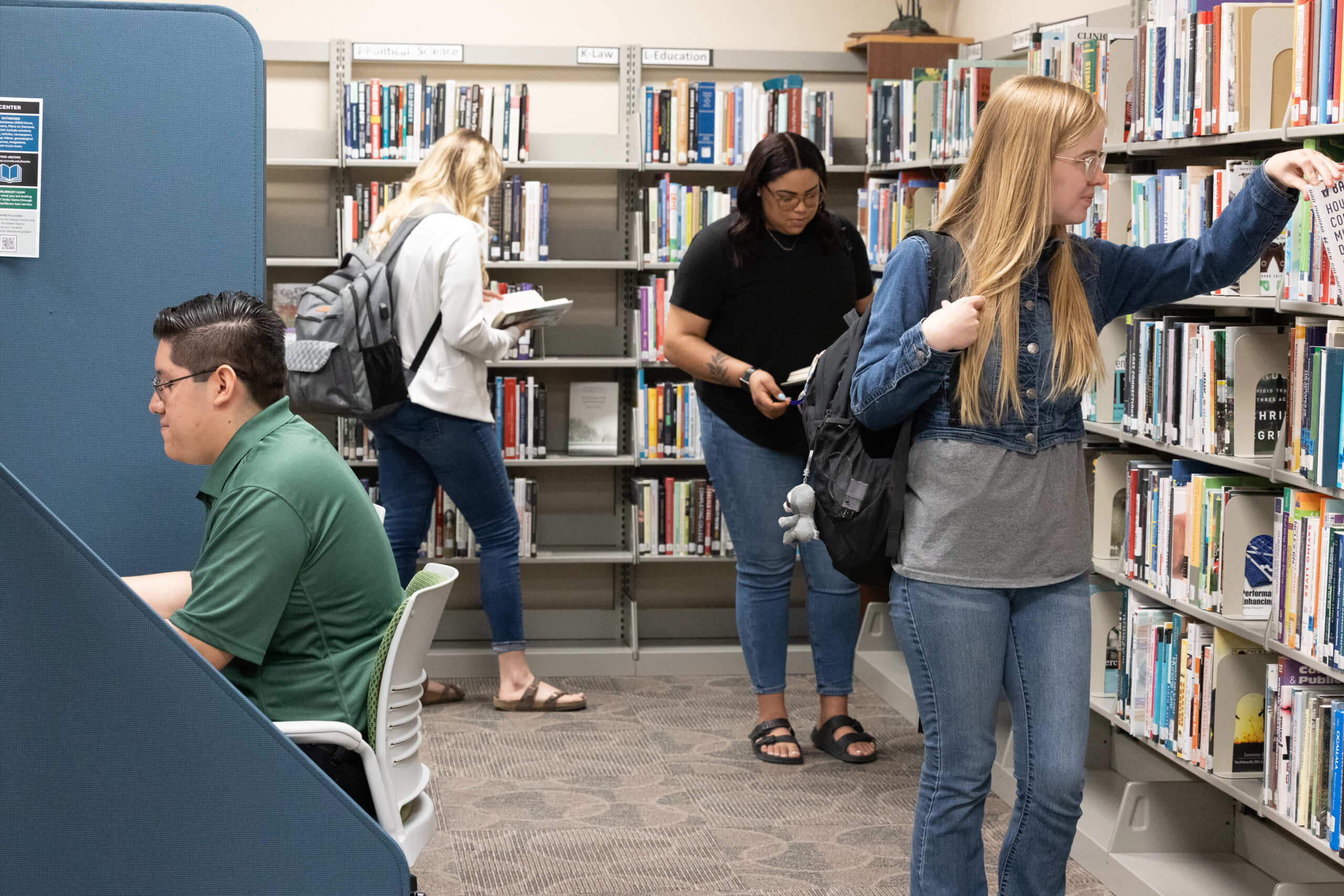 Group of students looking at books in the CCC library.