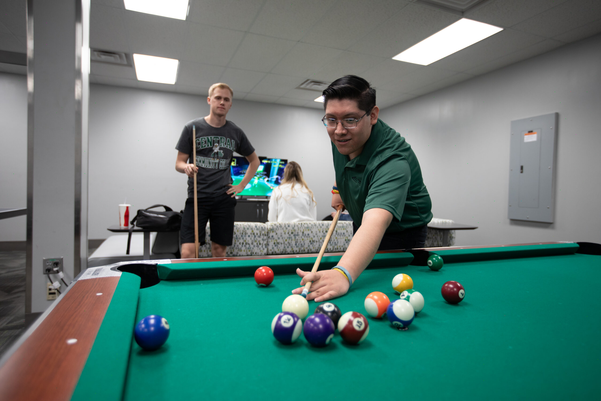Two students playing pool in lounge