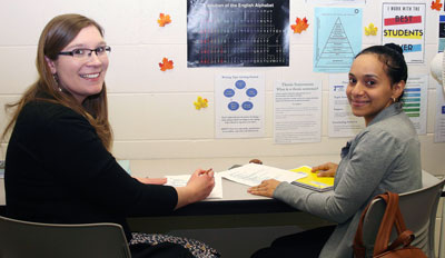 A tutor and student reviewing school work from a CCC course.
