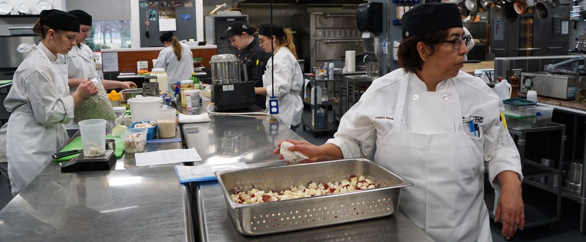 Students prepping for service in the kitchen at the Woodlands @Central.