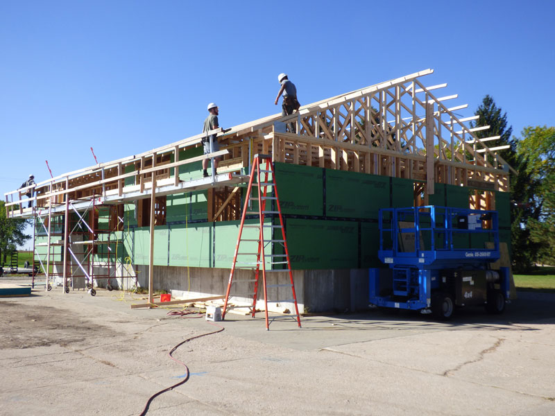Students working on top of house under construction