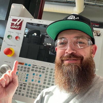 Steven Floyd posing in front of CNC machinery