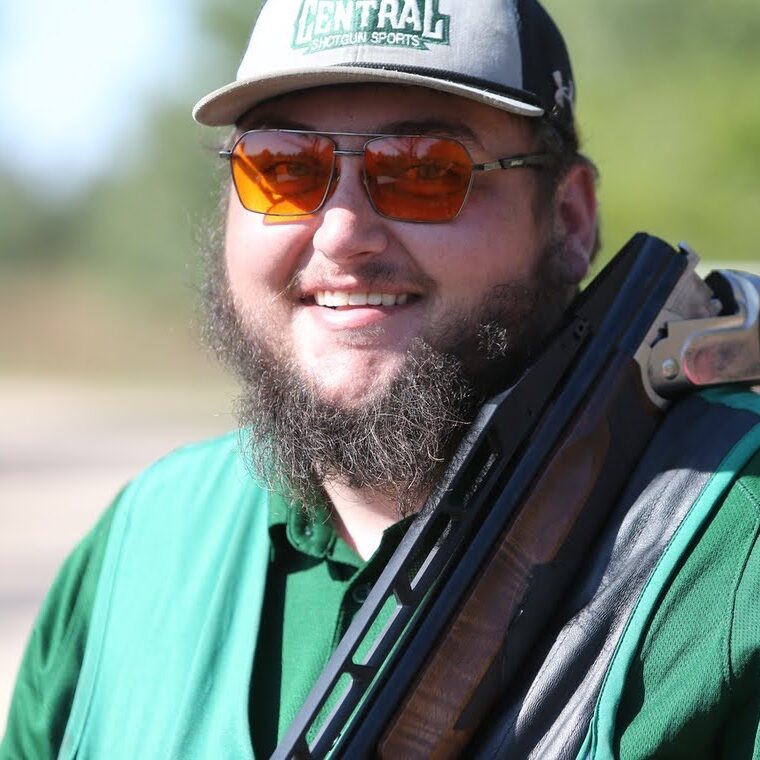 Syras Boston posing with a break-action rifle over his shoulder