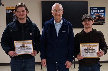 A pair of students pose next to Jim R. DeBord (middle) holding scholarship awards.