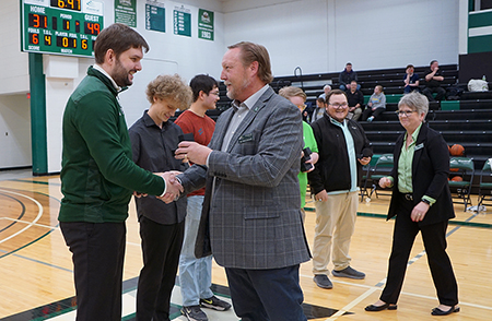 The esports team and head coach, Lucas Lumbra, receiving rings in a gymnasium.