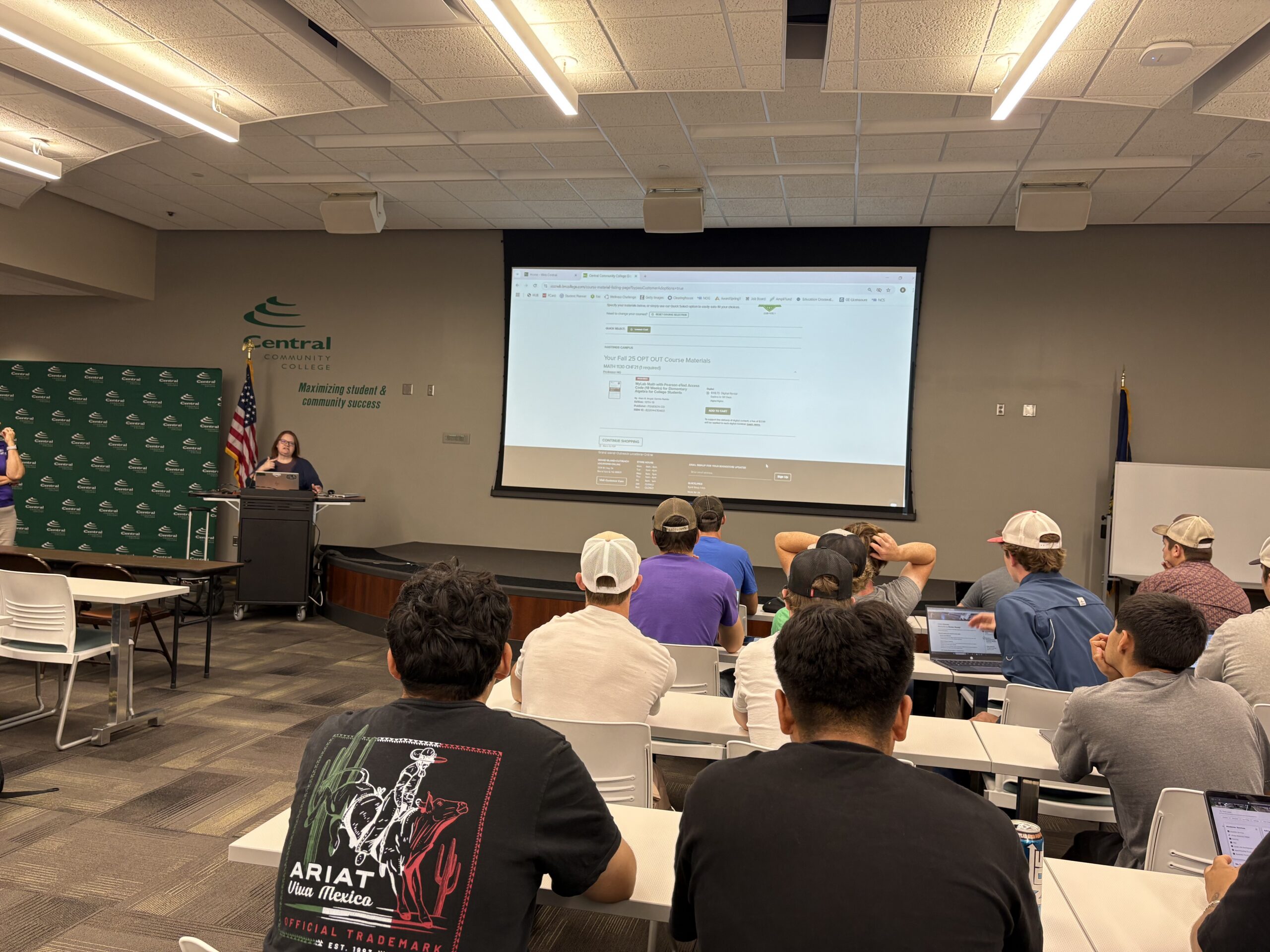 Instructor leads a financial aid workshop while students listen at classroom tables.